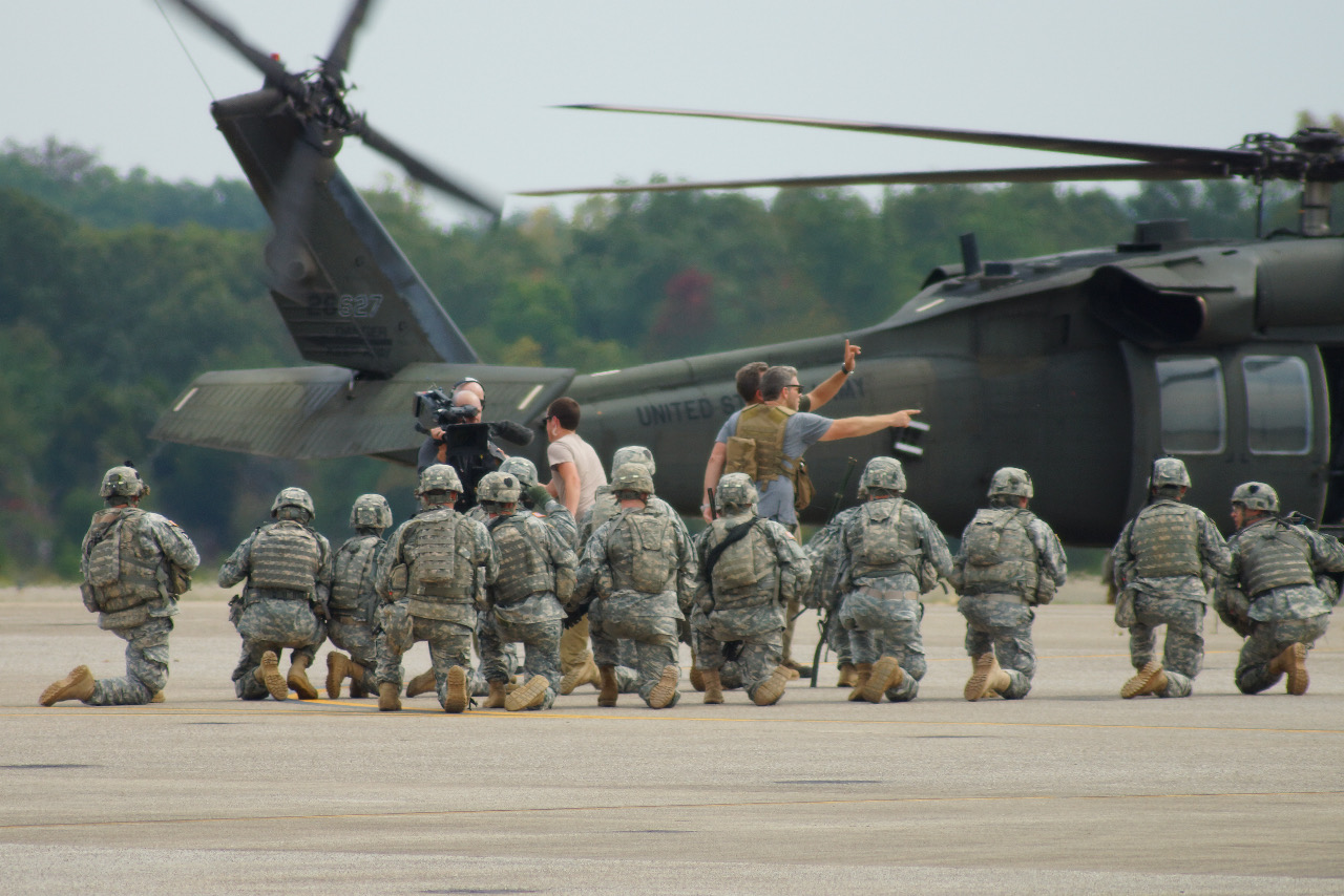 Camera crew and soldiers filming beside a helicopter during a Top Gear USA production